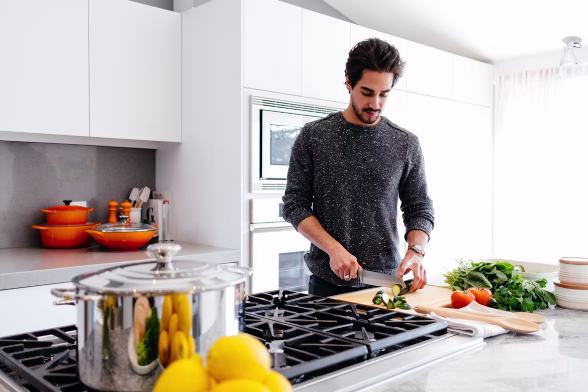 A man preparing vegetables in a bright home kitchen