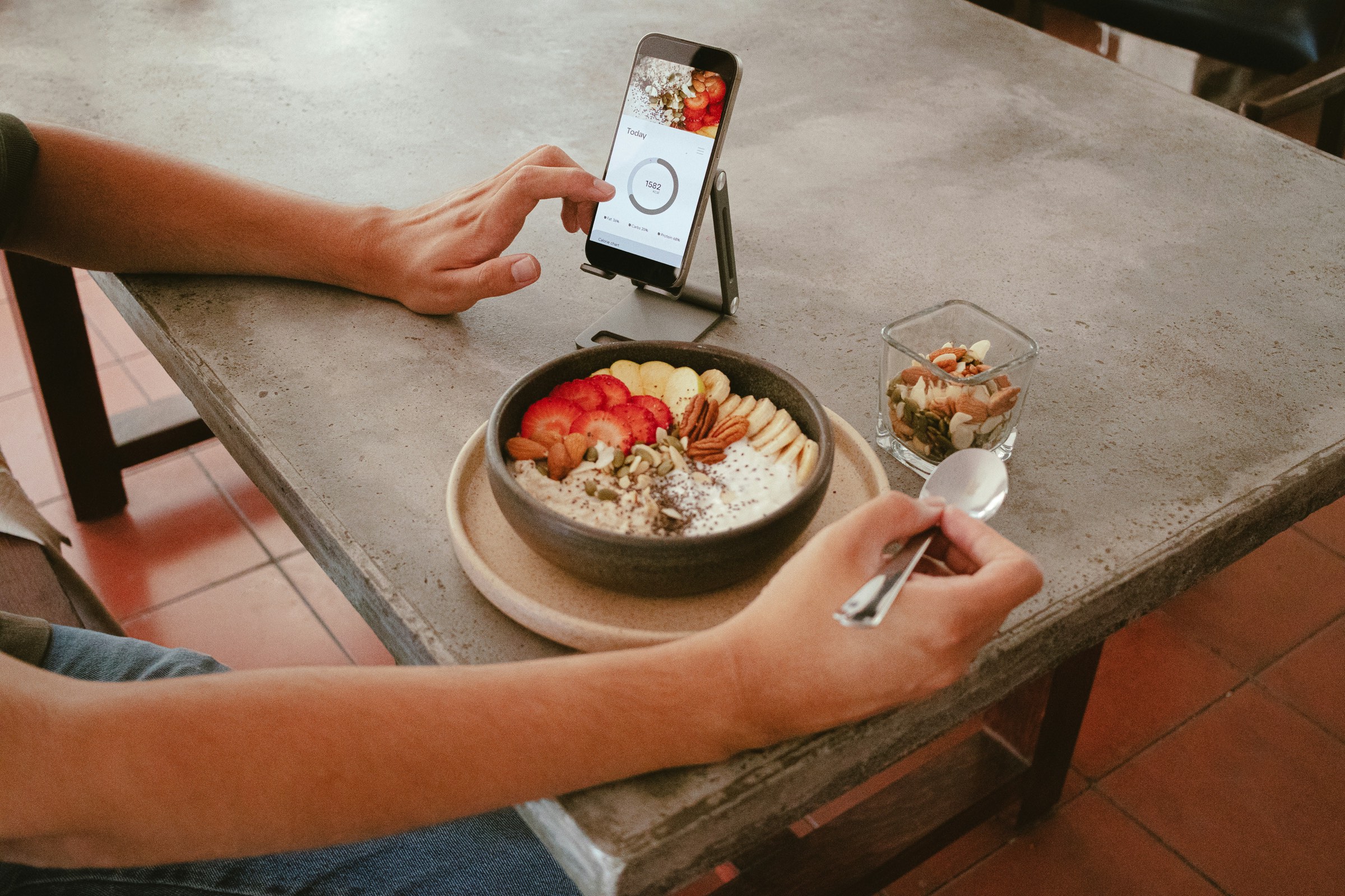 A person using a phone to track a meal while eating breakfast